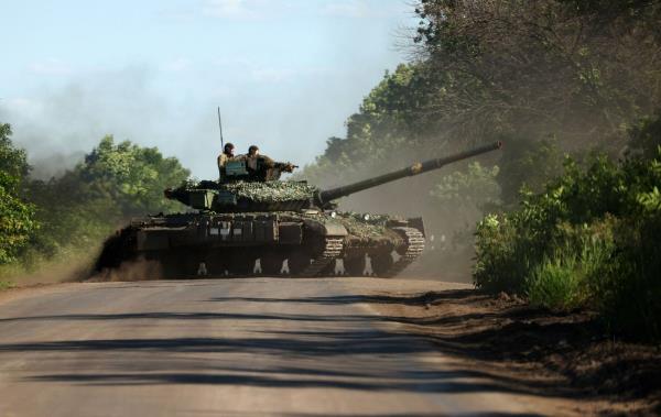 Ukrainian servicemen drive a tank on a road near the front line in the Do<em></em>netsk region of Ukraine on Wednesday. | GETTY IMAGES / VIA BLOOMBERG
